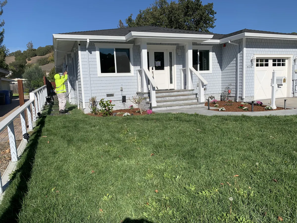 Freshly painted grey craftsman home with a white porch